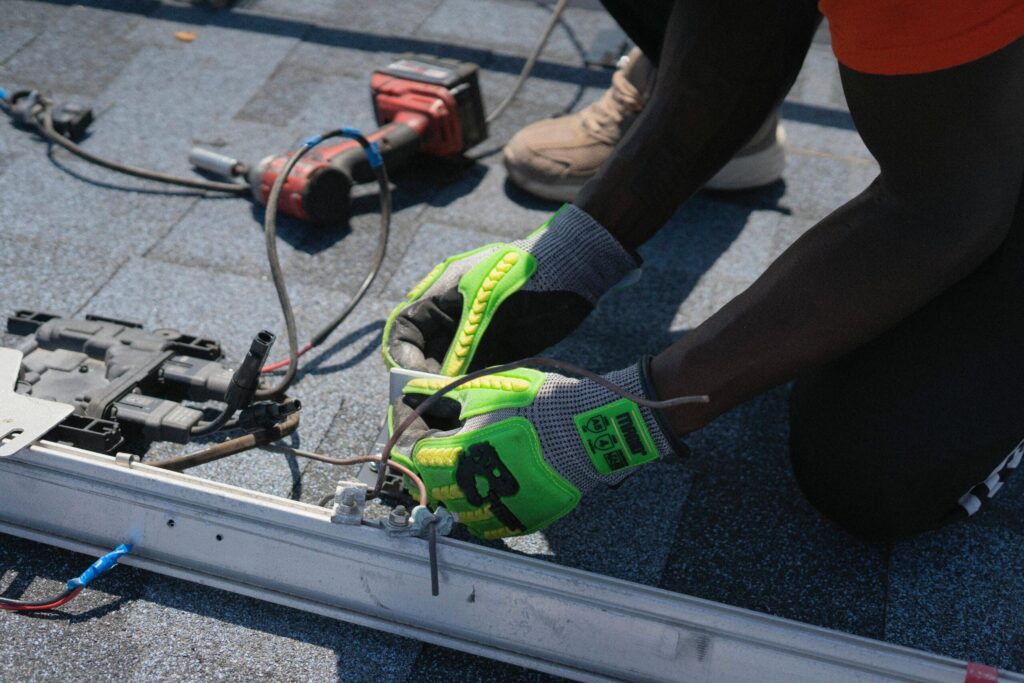 pexels-photo-33379360-33379360 Technician installing solar panels on a roof in Tampa, showcasing clean energy efforts.